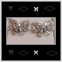 Bow shaped earrings with created diamond simulants.